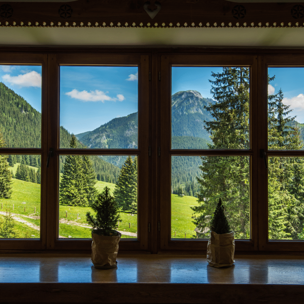 Scenic mountain and forest view from a timber frame home window in Alberta
