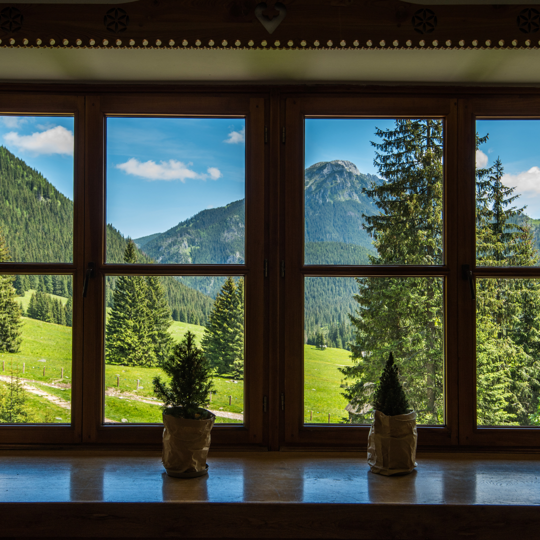 Scenic mountain and forest view from a timber frame home window in Alberta