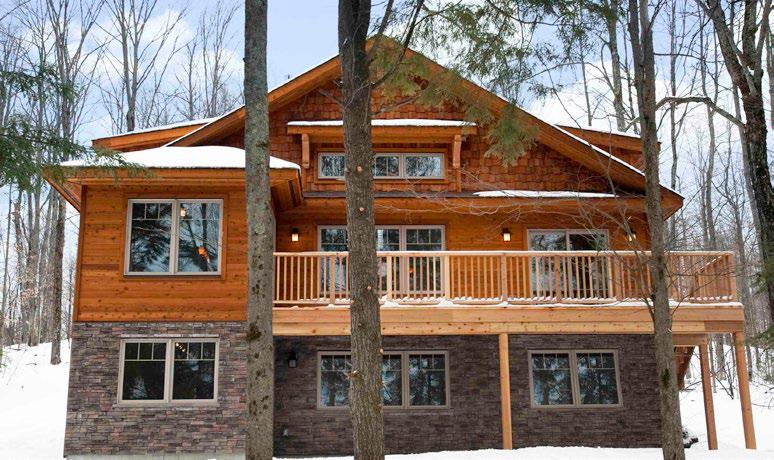 A large wooden house with a balcony and trees.